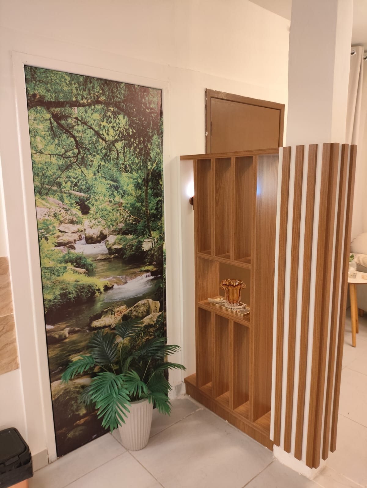 Entrada do consultório com painel de natureza e estante de madeira